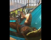 Girl eats pizza swings on hammock