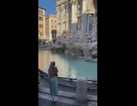 Woman in blue dress poses in front of the fountain