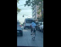 Mom rides bike with child on back