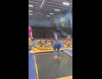 Girl jumps on trampoline, knees give out and she falls into orange blue foam pit