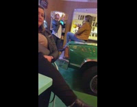 Girl poses with beer pitcher green car 