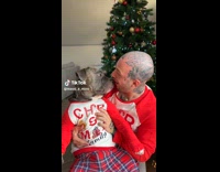 Man and dog wearing matching Christmas pajamas 