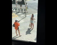 Girls take photos on sidewalk with phone