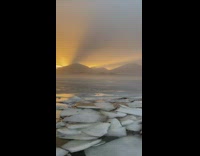 Broken ice pieces on the shore sunrise
