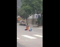 Grey sports bra girl sits middle street 