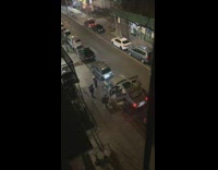 Man Poses Between Car Doors as Friend take Photographs