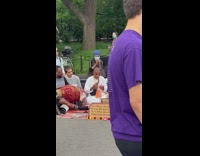 Performers play cultural dance music next to guy holding a sign
