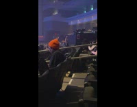 Woman leans on the rails raises feet inside the arena