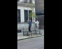 Two men in winter jacket tiktok dance on the sidewalk