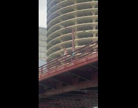Girl sit ledge metal railings red bridge