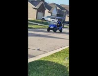 Blue go kart woman in cap and gown 