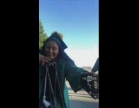 High school graduates in green cap and gown sing Hello by 1TakeJay