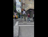 Guy rides tall bicycle down the street