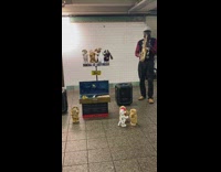 Guy plays saxophone with dancing dolls station