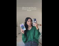 Girl in green shirt holding iPhone and box 