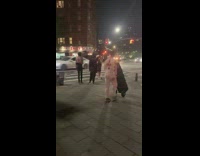 Guy in white pushes loud disco speaker down street 