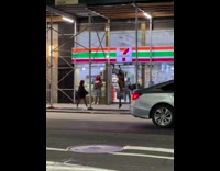 Two people dancing around outside a convenience store