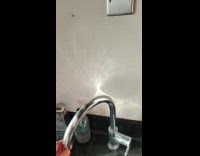Light reflects on metal tap at wall