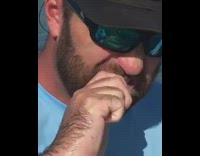 NSFW blue shirt guy with reflective sunglasses bites off fish head spits it out then shotguns beer