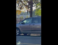 Guy drives his bicycle with thing on top of his head 