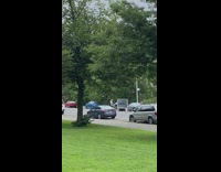 2 people push a chalkboard down a street 