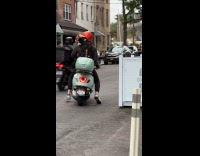 Guy carries dog with goggles rides motorcycle