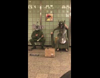 two people in silver animal masks play instruments