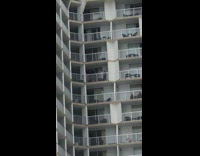 Two girls dance outside on white balcony