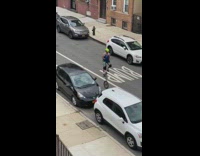 Green helmet guy rides unicycle street cars