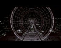 Drone flies by large ferris wheel chain 