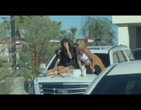 Two women sits on the car hood at the parking lot