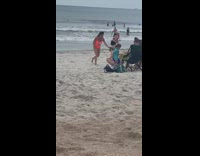 Woman orange swimsuit kneel drink can beach