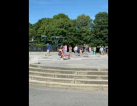 Woman crouches and lifts girl to pose at the park