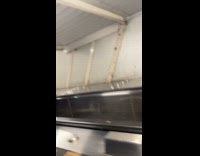 Teens climbing up on metal platform next to escalator 