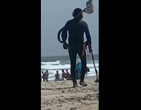Collab Kook Of The Day - Black wetsuit guy metal detector beach sand 