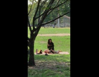 Woman takes picnic with her bulldog at the park 