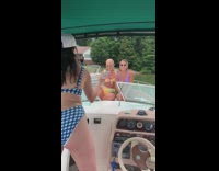 Two girls swimsuit sit front boat lake
