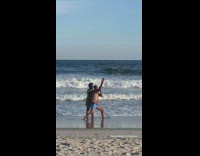 Woman poses behind the man for a selfie photoshoot at the beach
