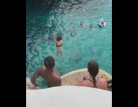 Girl jumps off rock cliff into water