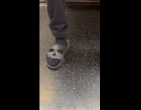 Collab Subway Creatures - Man wears skull slippers on train ride