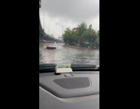 Car drive through flooded part of street