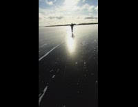 Guy ice skates across frozen lake friend