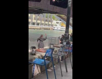 Woman in black dress dance near the restaurant and the river
