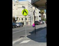 Girl checkered pants skate shoes street sign