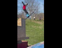 Kid falls face first onto tarp when landing off ski ramp 