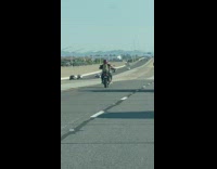Motorcyclist air drum solo along the highway