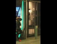 Guy in denim jacket poses against wall with green light