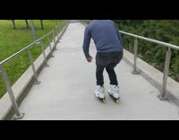 Guy on white rollerblades rides metal railing 