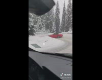 Two cars driving down snow mountain slowly