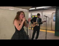 Collab Subway Creatures - Woman in black dress and guy in suit play guitar and sing to Shallow lady gaga song
